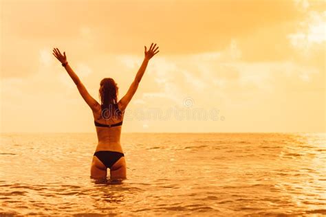 Woman S Silhouette With Raised Arms Against Calm Sunset Beach Stock