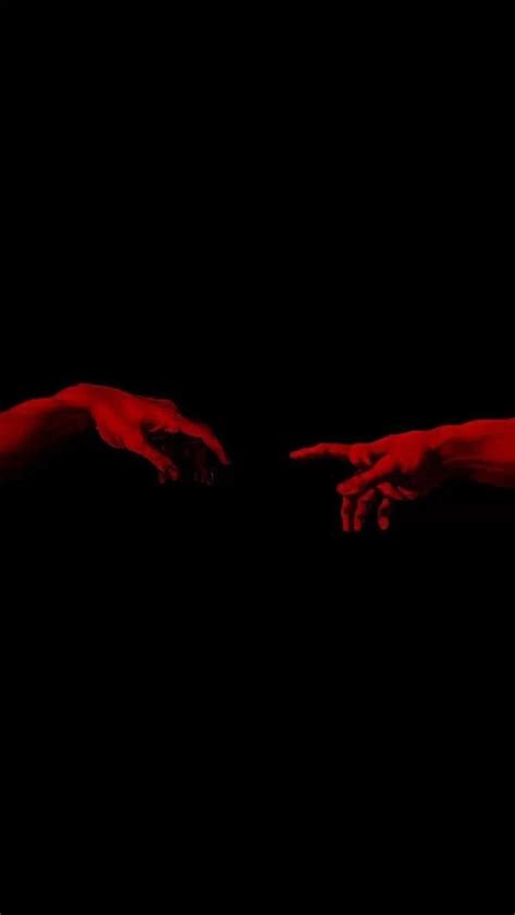 Two Hands Reaching Towards Each Other With Red Paint On Their