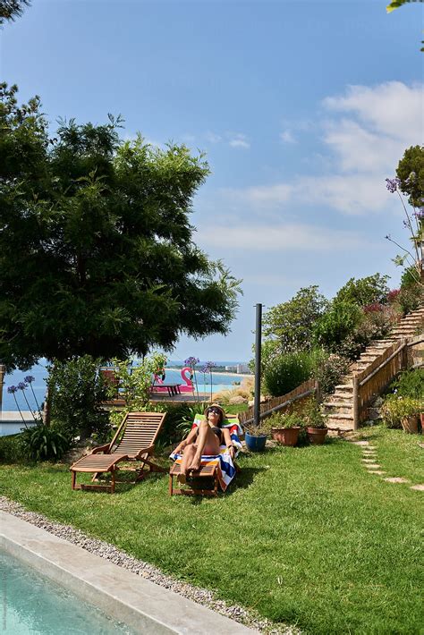 Brunette In Bikini And Hat Sunbathing On Deckchair By Stocksy Contributor Guille Faingold