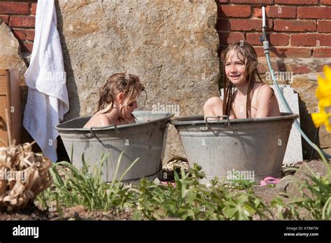 Zwei blonde Mädchen Geschwister scholl Baden im Garten in zwei Zinkwannen Erfrischung im