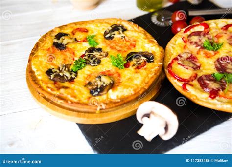 Pizza De Champignon Et De Pizza Aux Légumes Et De Salami Au Fond Photo