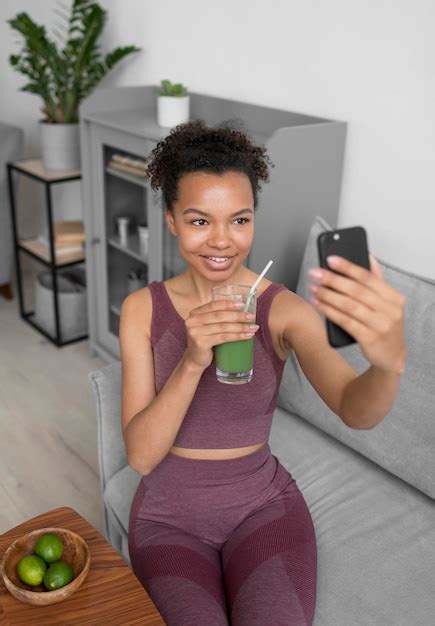 Mulher Fitness Tirando Uma Selfie Enquanto Toma Um Suco De Fruta Foto