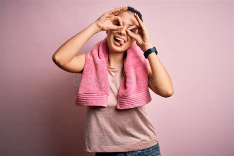 Joven Y Hermosa Deportista De Brunette Con Ropa Deportiva Y Toalla Sobre Fondo Rosa Haciendo