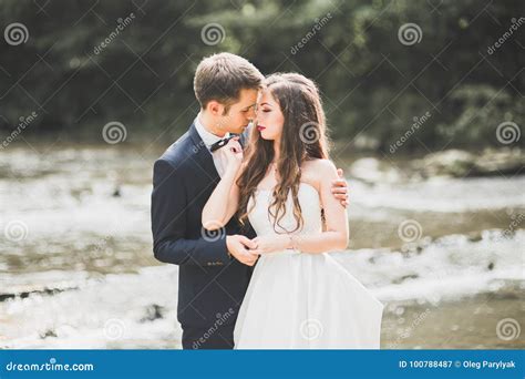 Beautifull Wedding Couple Kissing And Embracing Near The Shore Of A