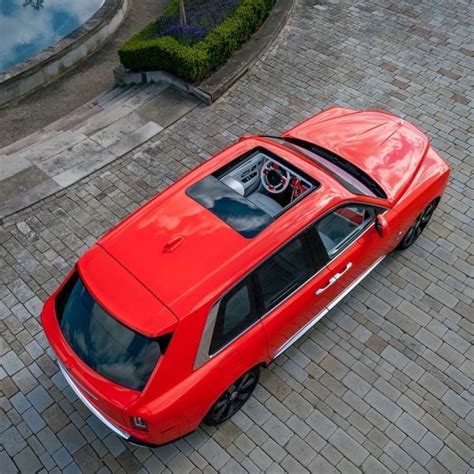 An Overhead View Of A Red Car Parked On The Side Of A Brick Road In