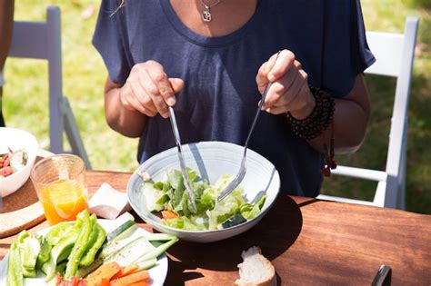 Primer Plano De Mujer Comiendo Ensalada En La Mesa Al Aire Libre Foto