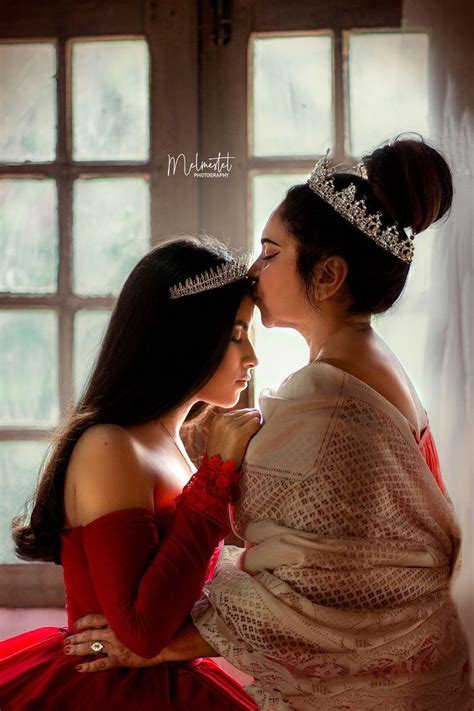 Two Women In Red Dresses Are Kissing Each Other And One Is Wearing A Tiara