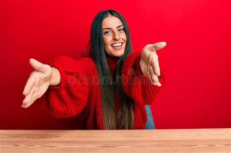 Beautiful Hispanic Woman Wearing Casual Clothes Sitting On The Table