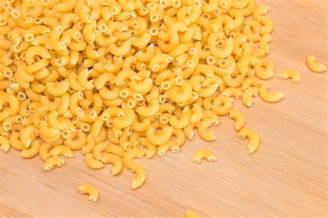 Premium Photo A Heap Of Uncooked Chifferi Rigati Pasta On Wooden