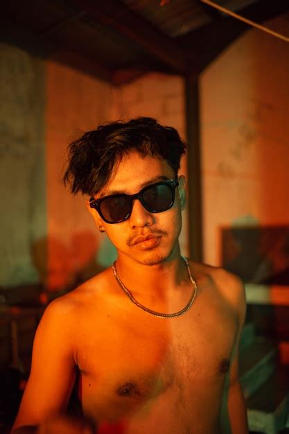 Premium Photo A Gay Guy In Sunglasses And Denim Pants Posing Very Naughty
