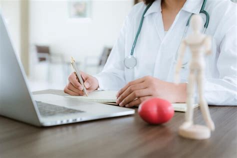 Premium Photo Midsection Of Doctor Writing On Book