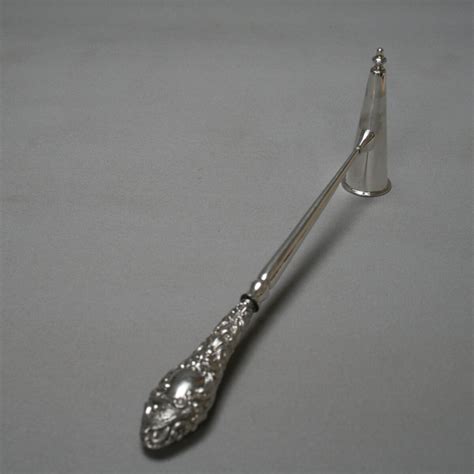 A medium sized candle snuffer with silver handle - Williams Antiques