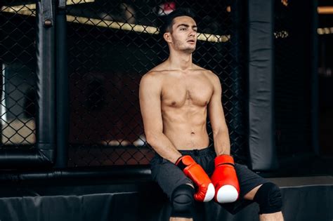 Premium Photo Sportsman With A Naked Torso And The Red Boxing Gloves On His Hands Sits On The