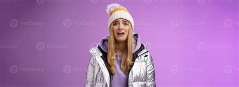 Upset sobbing miserable cute blond woman in silver stylish jacket hat