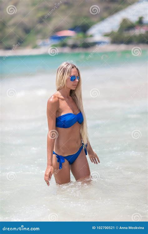 Blonde Frau Im Blauen Bikini Auf Weißem Tropischem Strand Stockbild