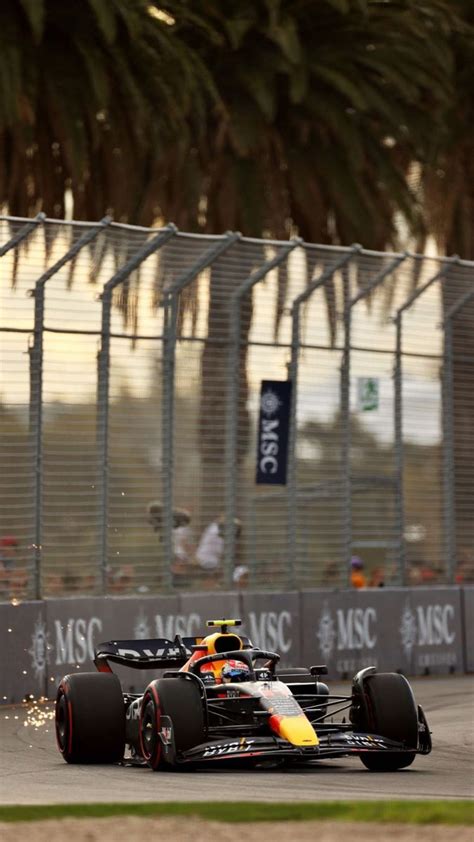 A Red And Yellow Race Car Driving Down The Track