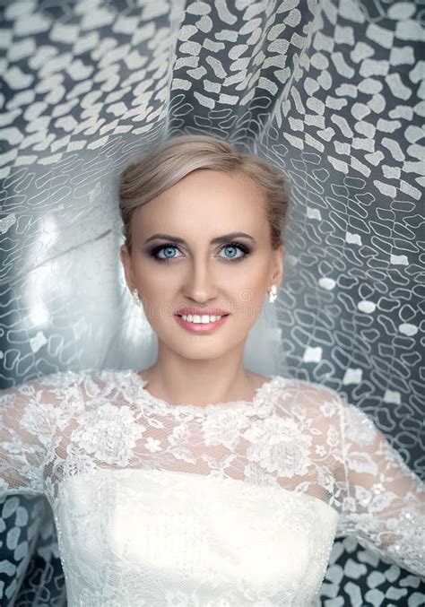 Beauty Fresh Blonde Woman With Beautiful Blue Eyes In White Bridal Dress Posing Stock Photo