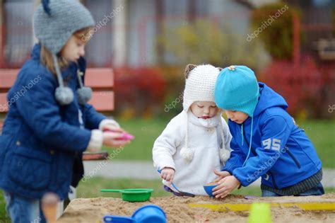 Three Kids Playing In A Sandbox Stock Photo By ©mnstudio 43464209