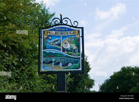 Wood and metal Pulborough Village sign featuring Stopham Bridge, main street and the Parish ...