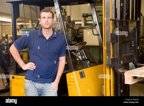 Warehouse Worker Standing By Forklift Stock Photo Alamy