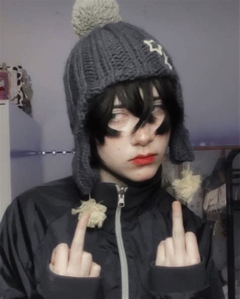 a woman with black hair wearing a gray hat and making the peace sign in ...