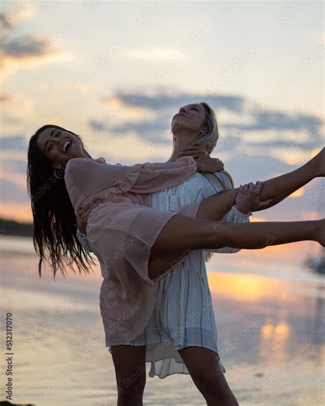 Dos chicas pasando un dia en la playa en bikini y traje de baño Stock Foto Adobe Stock