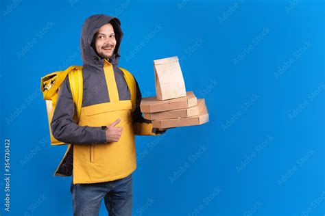 Foto De Unshaven Dark Haired Caucasian Courier In Yellow Windbreaker