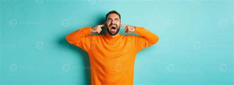 Frustrated and annoyed man shouting at neighbours upstairs, shut ears