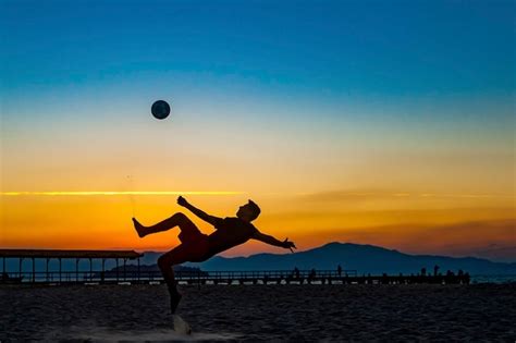 Esporte Com Bola E Rede Praticado Na Praia - Rapaz praticando esportes com bola na praia em pleno pôr do sol de ...