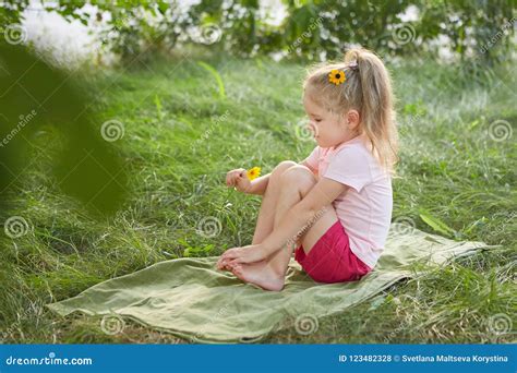 Little Girl Is Sitting On The Grass Stock Photo Image Of Spring Stem