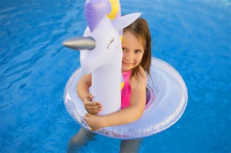 Premium Photo | Child in swimming pool on unicorn inflatable violet ring