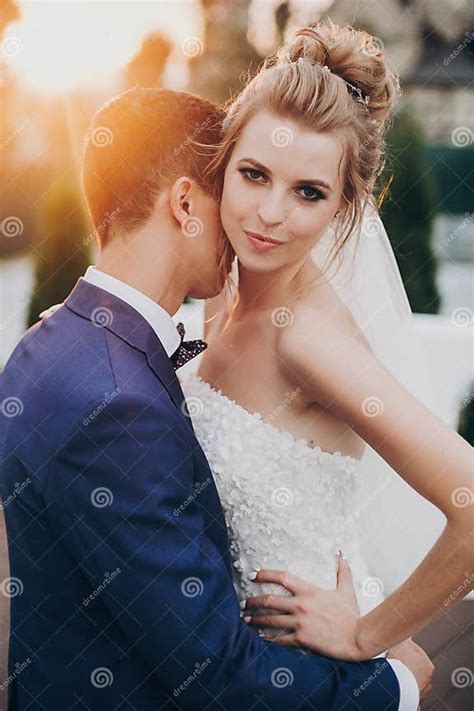 Stylish Happy Bride And Groom Posing In Warm Sunset Light At Wedding