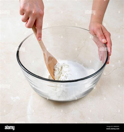 Mixing Flour And Caster Sugar In Mixing Bowl Using Wooden Spoon To