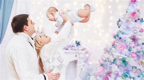 Premium Photo | Loving parents with play with their baby standing in ...