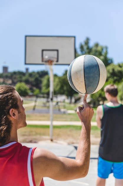 Jugador De Baloncesto Que Hace Girar La Bola En Su Dedo Foto Gratis