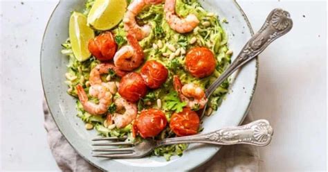 A White Plate Topped With Shrimp Tomatoes And Lettuce Next To A Fork