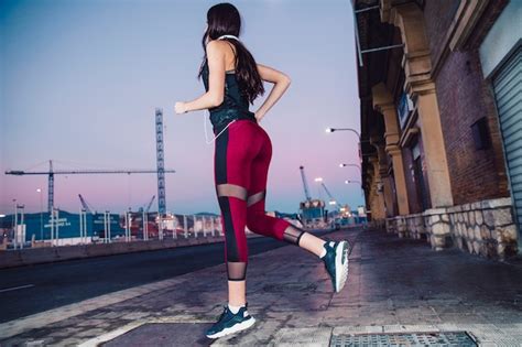 Junger Brunette der auf Straße läuft Kostenlose Foto
