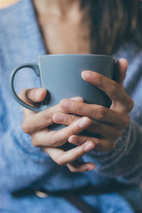 Woman Holding A Cup Of Tea Between Her Hands By Stocksy Contributor