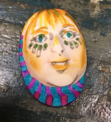 A Painted Face On A Piece Of Wood