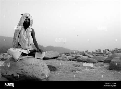 A Man Meditates On A Rock In The Holy River Of Ganges In Rishikesh In