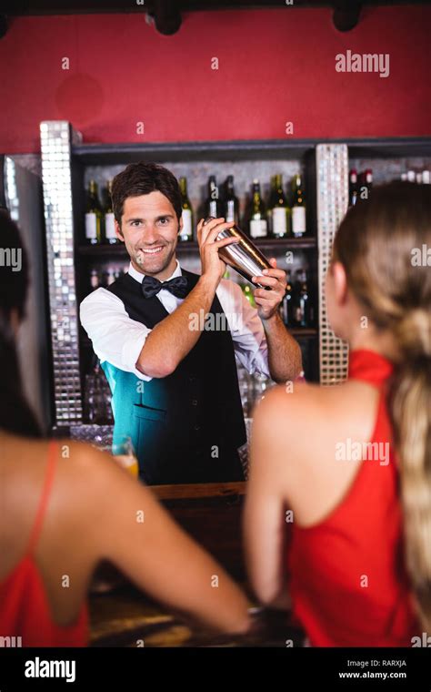 Bartender Shaking Cocktail In Cocktail Shaker At Bar Counter Stock