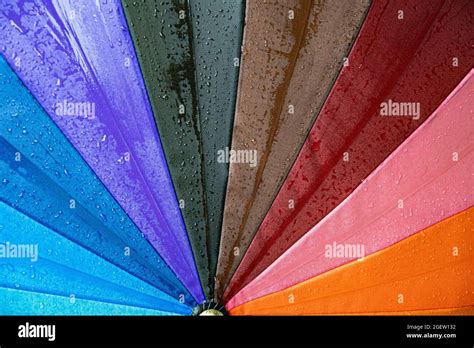 Wet Surface Of Rainbow Umbrella Under Drizzle Rain Drops Dripping At