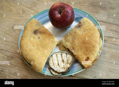 Two Wedges Of Stuffed Focaccia Placed Facing Each Other With An Apple