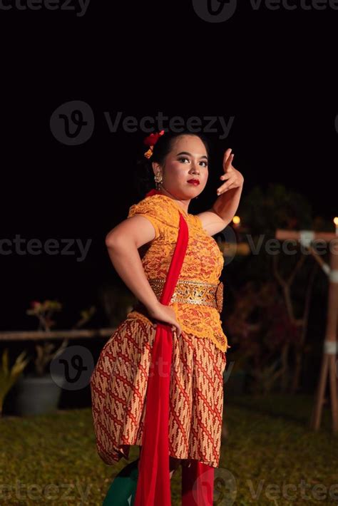 Balinese dancers in yellow color traditional costumes present the dance ...