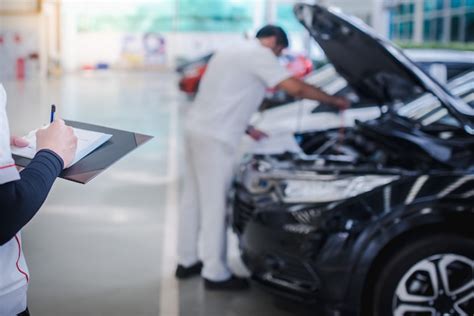 El mecánico de automóviles asiático está revisando el motor y