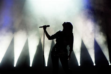 Sänger der zum Mikrofon singt Sänger in der Silhouette Premium Foto