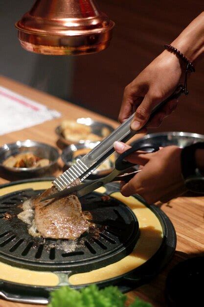 Una Persona Que Usa Un Par De Tenazas Para Cortar Carne En Una Sart N