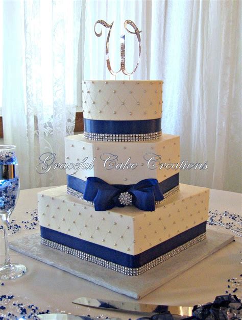 A Three Tiered Wedding Cake With Blue Ribbon