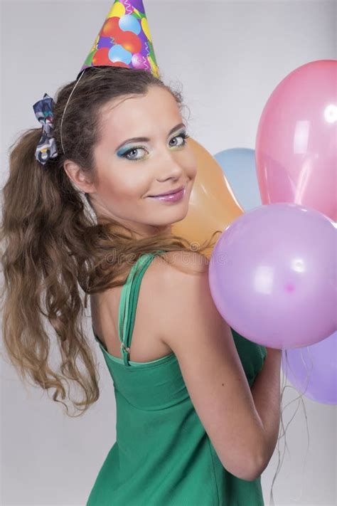 Brunette Woman In A Birthday Cap Holding Balloons And Smile Stock Image