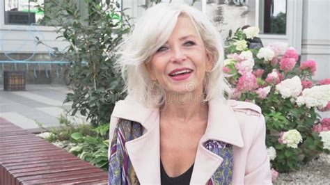 Slow Motion Mature Woman With Silver Hair Looking Straight Into The Camera Laughing The